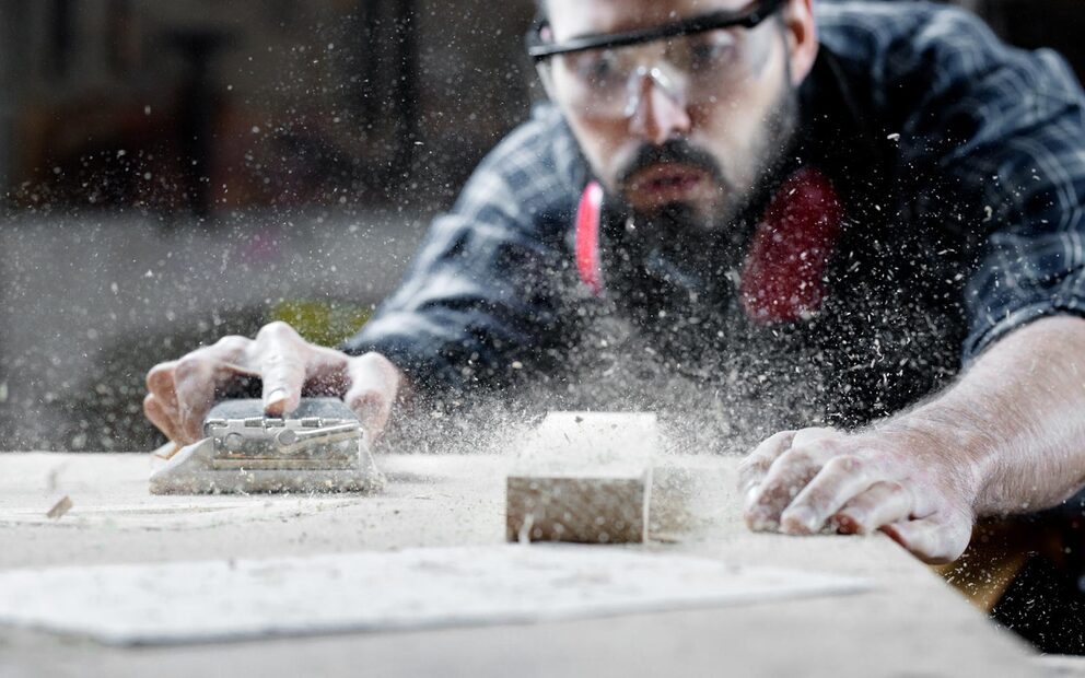 Handwerker bearbeitet Holz in der Werkstatt